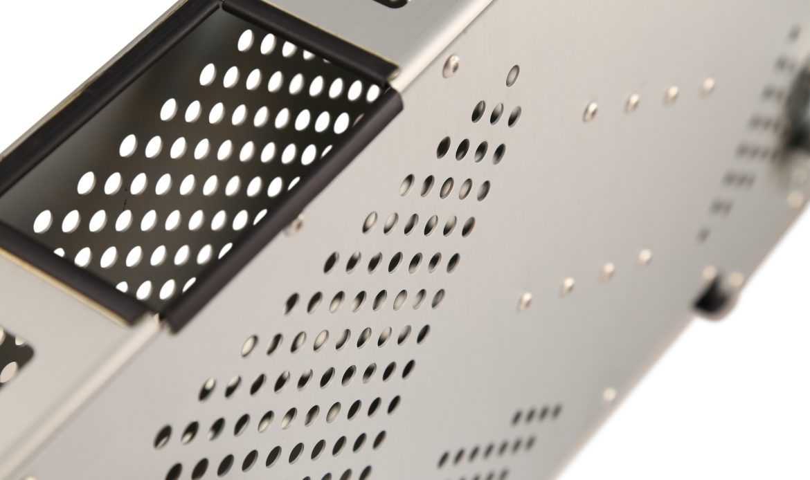 aerospace Close-up of a perforated metal enclosure with circular ventilation holes and a brushed finish, commonly used for electronic or industrial equipment.