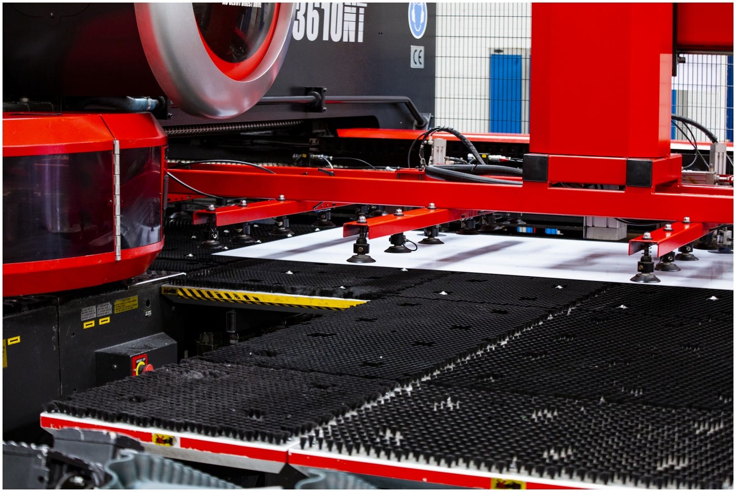 Close-up of a large industrial machine with red components in a manufacturing facility.